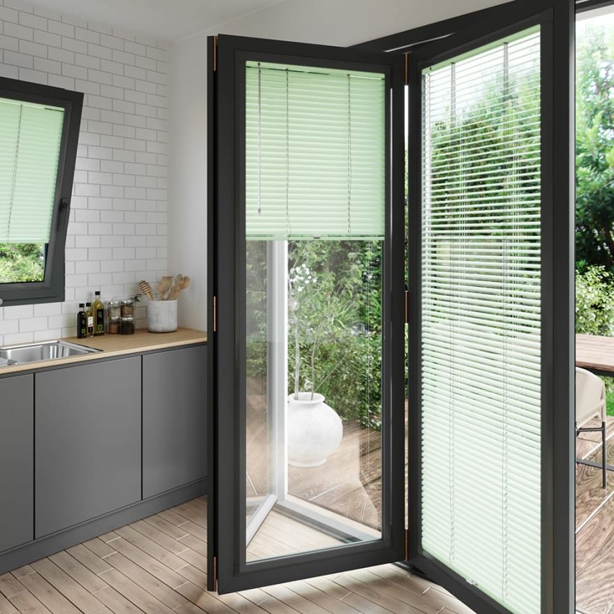 A pale green coloured perfect fit blind on a set of anthracite bifold doors